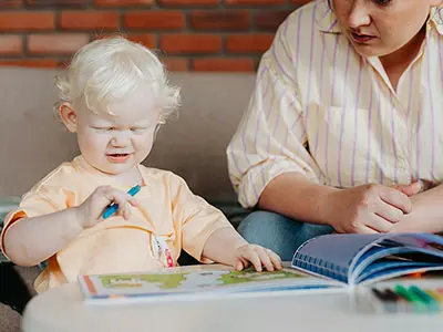 Young child and her mother looking at a book
