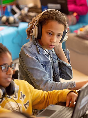 young student with headphones using a computer