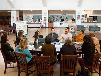 Agency leaders sitting around a conference table having an active discussion.