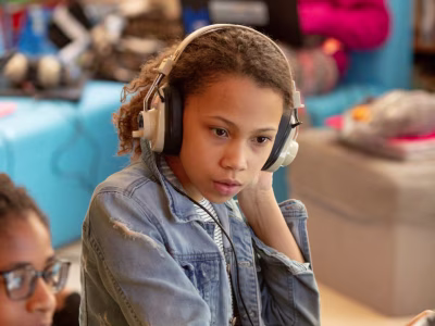 Student wearing headphones at laptop.